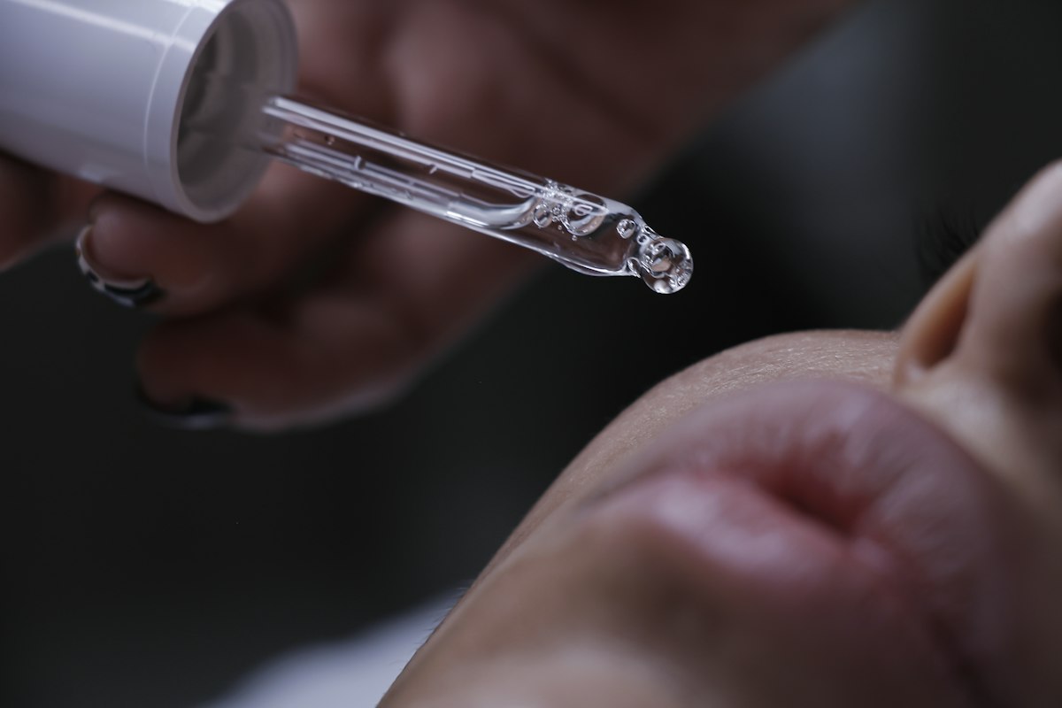 Conta-gotas de sérum sendo aplicado na pele